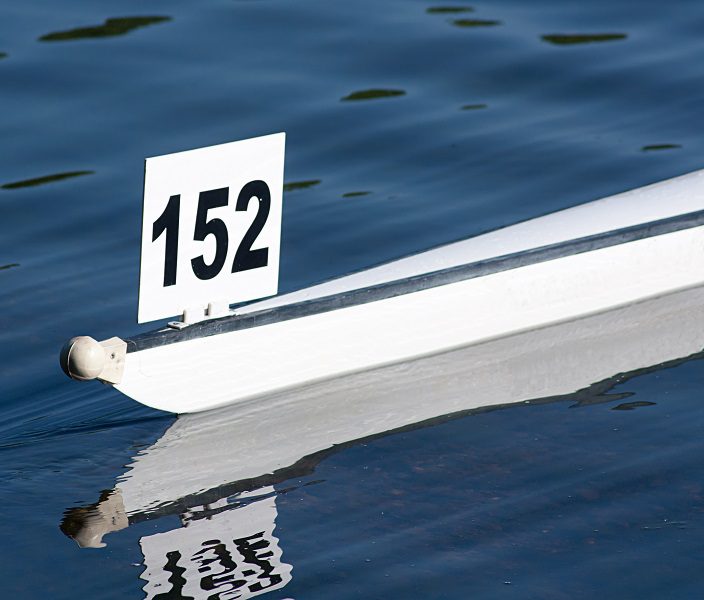 A model boat with the number 152 floats on water.