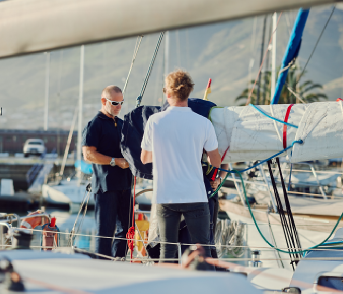 Two men on a sailboat preparing for sailing.