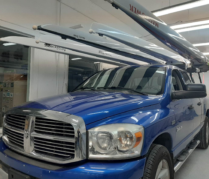 Blue Dodge pickup truck with a roof rack in a garage.