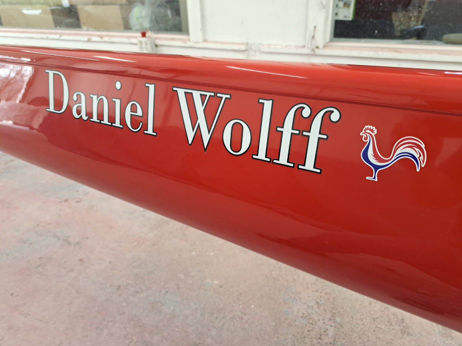 Red sign with the name Daniel Wolff and a small rooster graphic.
