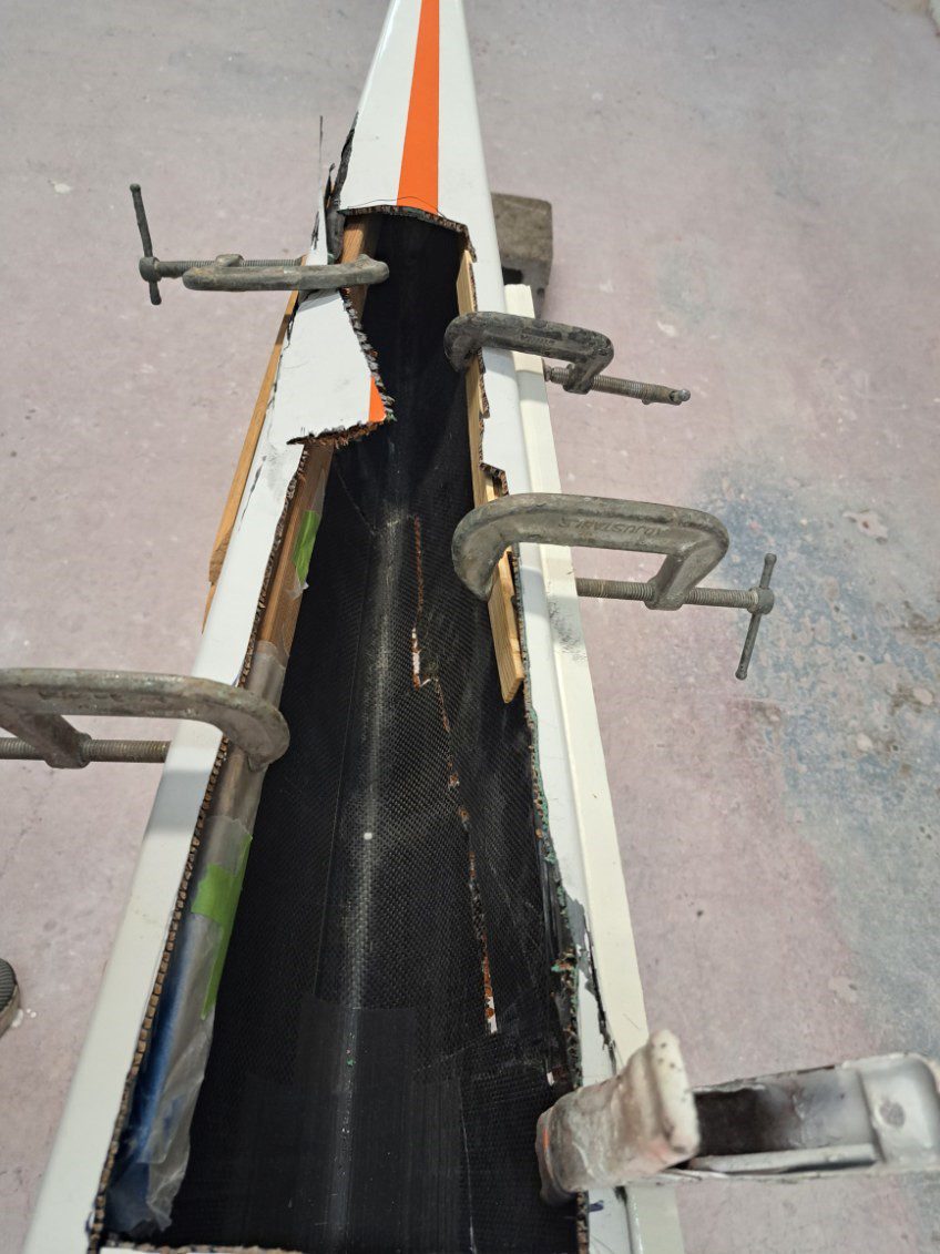 Clamps securing construction materials on a concrete surface.