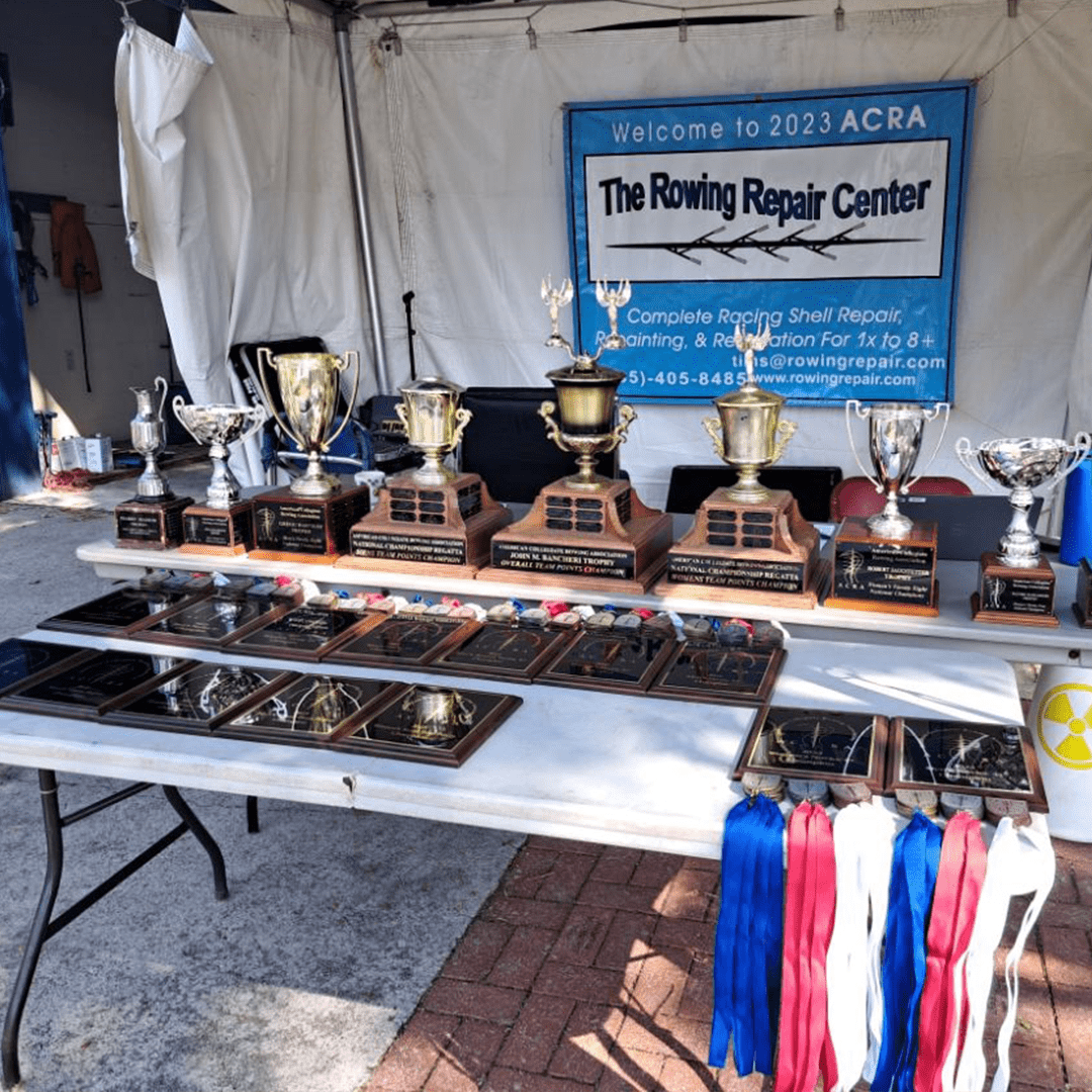 Trophies and awards displayed at a rowing event booth.