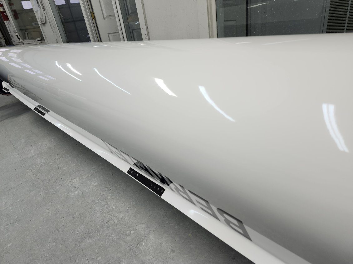 Close-up of a sleek white industrial machine with reflective surface.