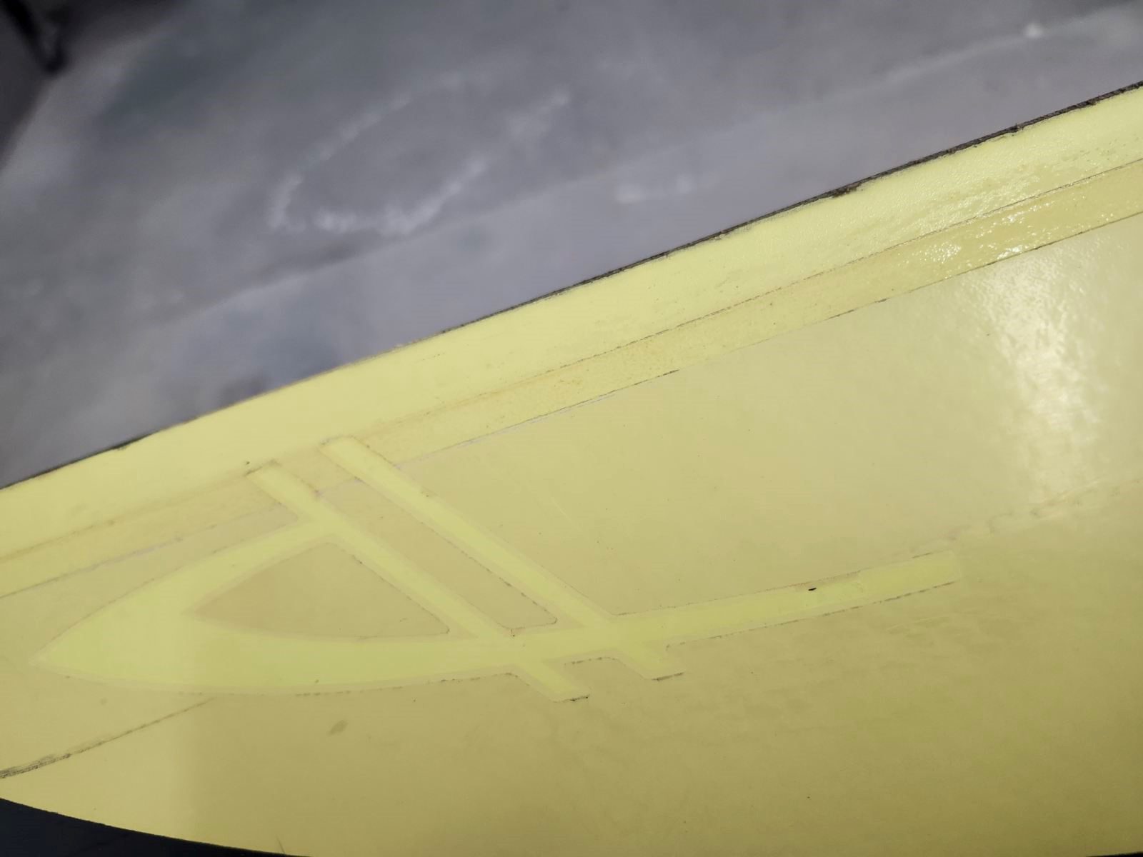Close-up of a yellow-painted ceiling corner with a textured wall above.