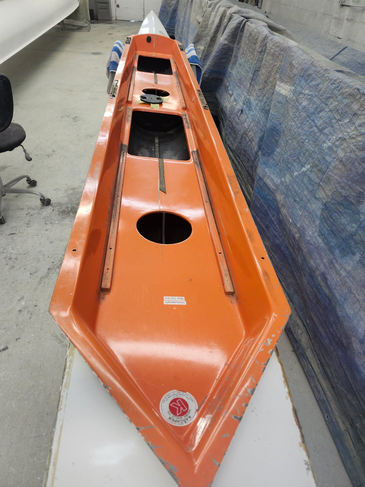 Orange industrial conveyor or machinery part with openings and a gauge.