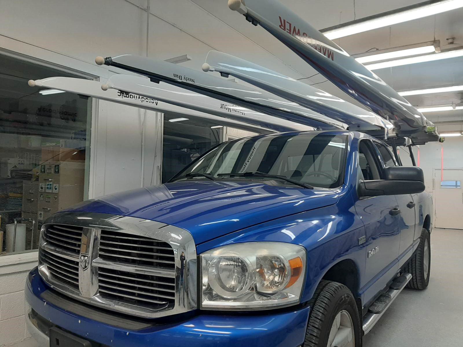 Blue Dodge truck with roof racks in a garage.