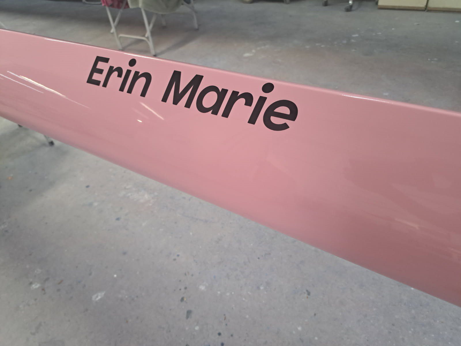 Pink swing seat with the name Erin Marie on it.