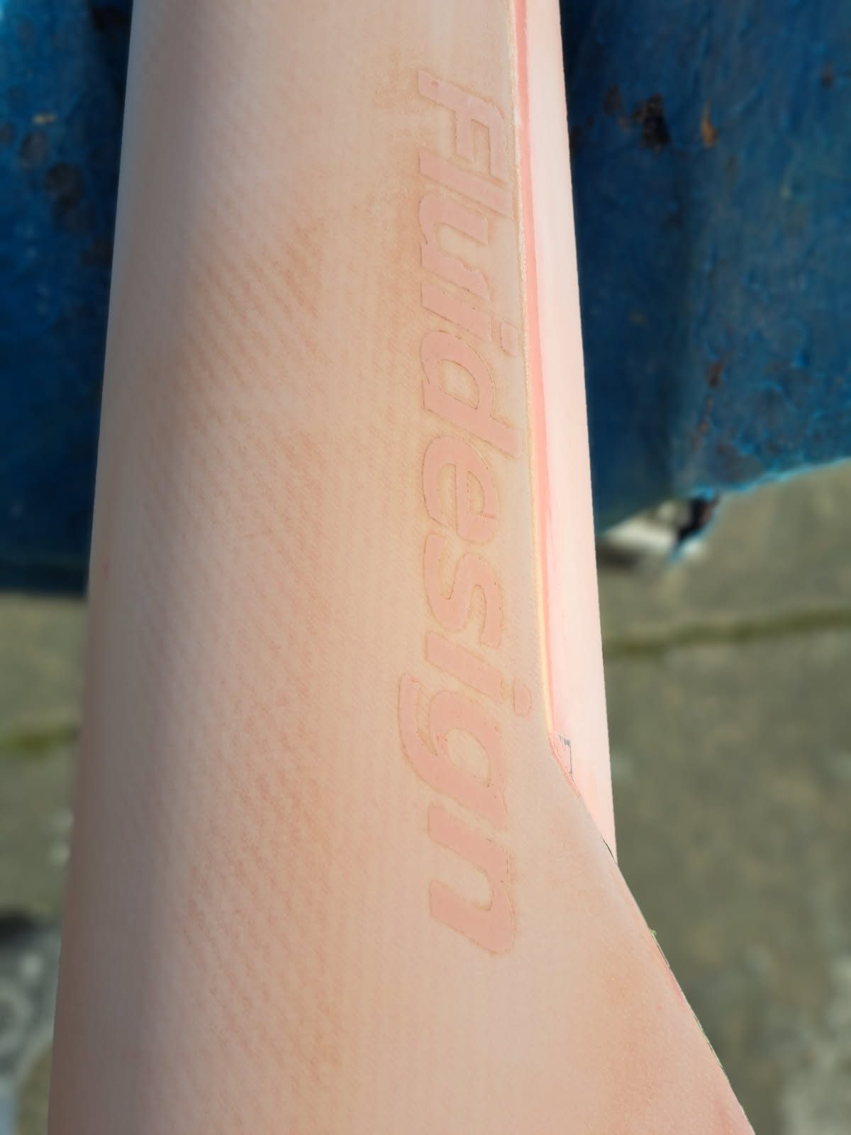 Close-up of a peach-colored object with textured surface and embossed text.