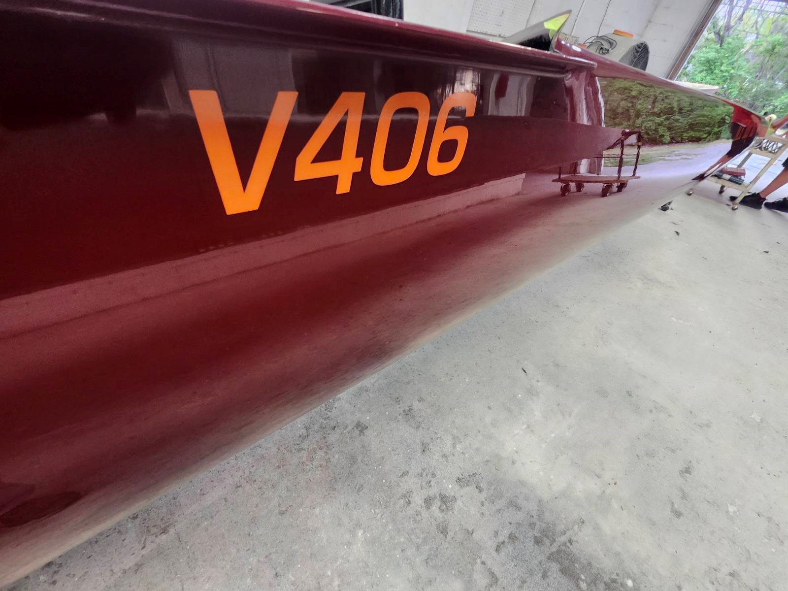 Close-up of a maroon boat with 'V406' in orange lettering.