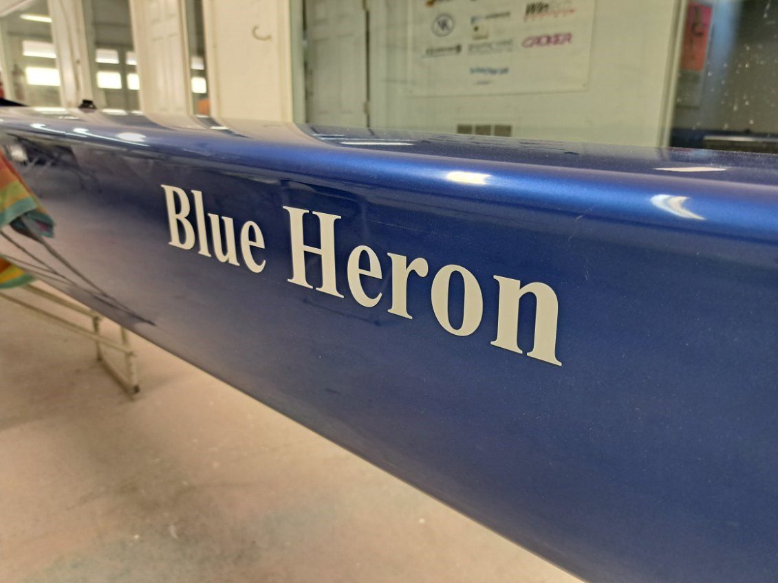 Close-up of a blue canoe paddle with 'Blue Heron' text.