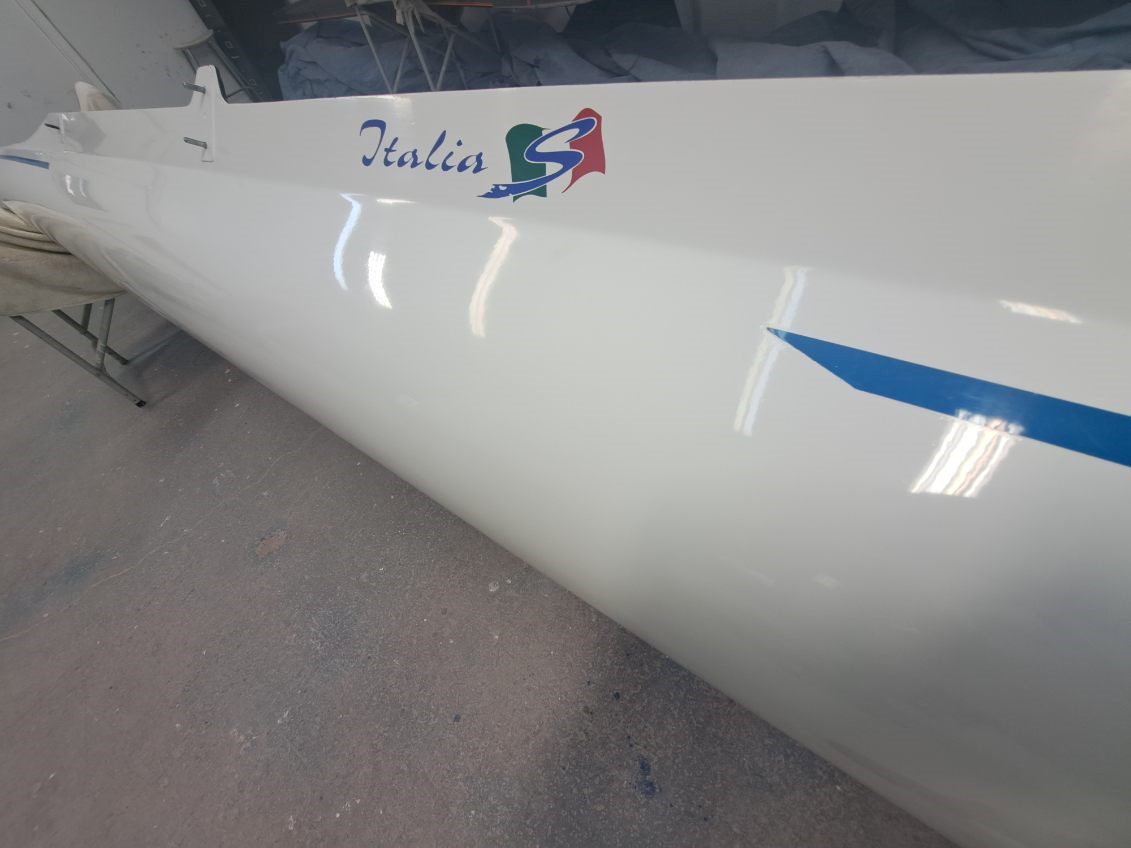 Close-up of a white glider wing with 'Italia' and an Italian flag decal.