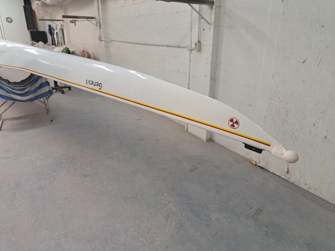 A white kayak with a star logo on the side indoors.