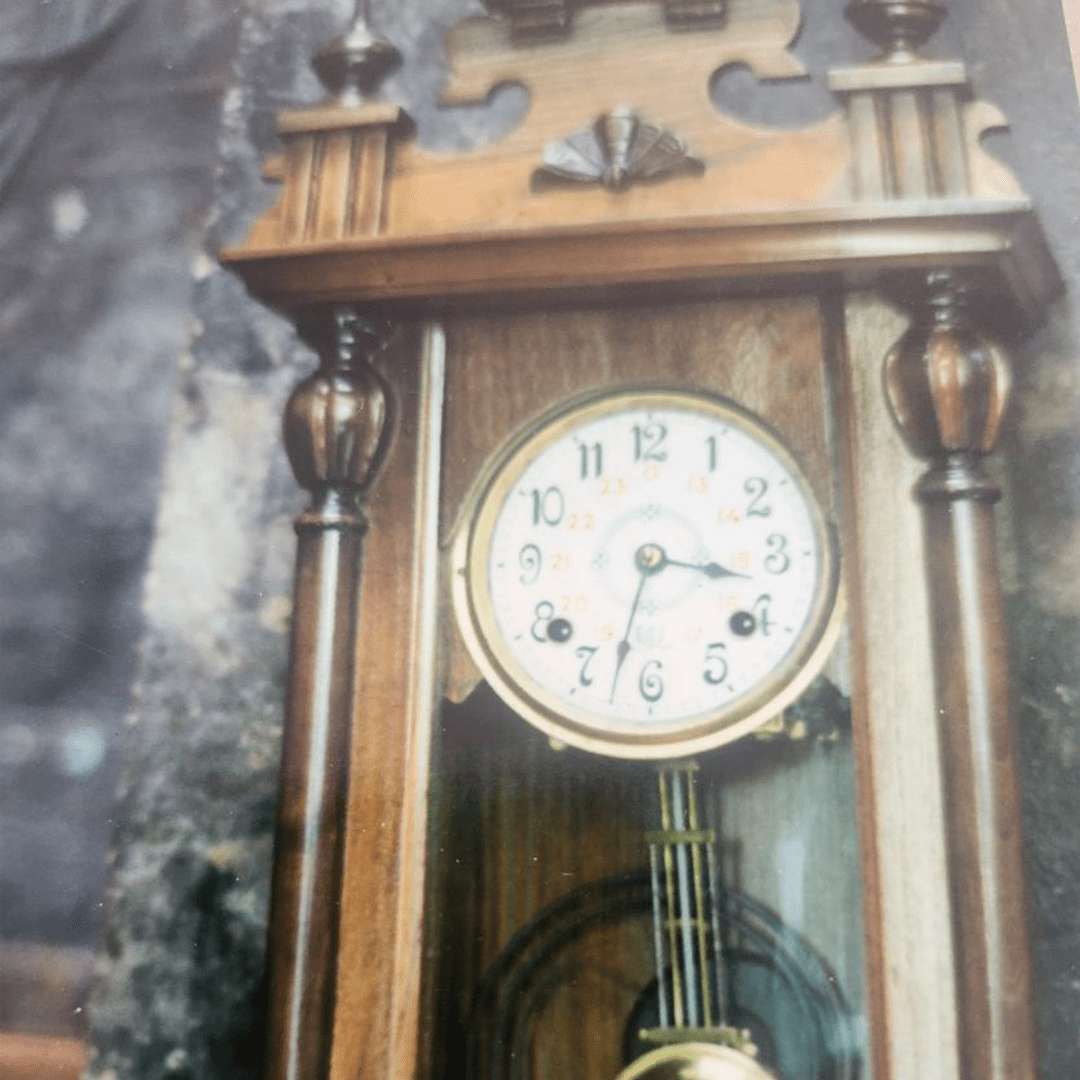 An antique wooden pendulum clock with intricate details.
