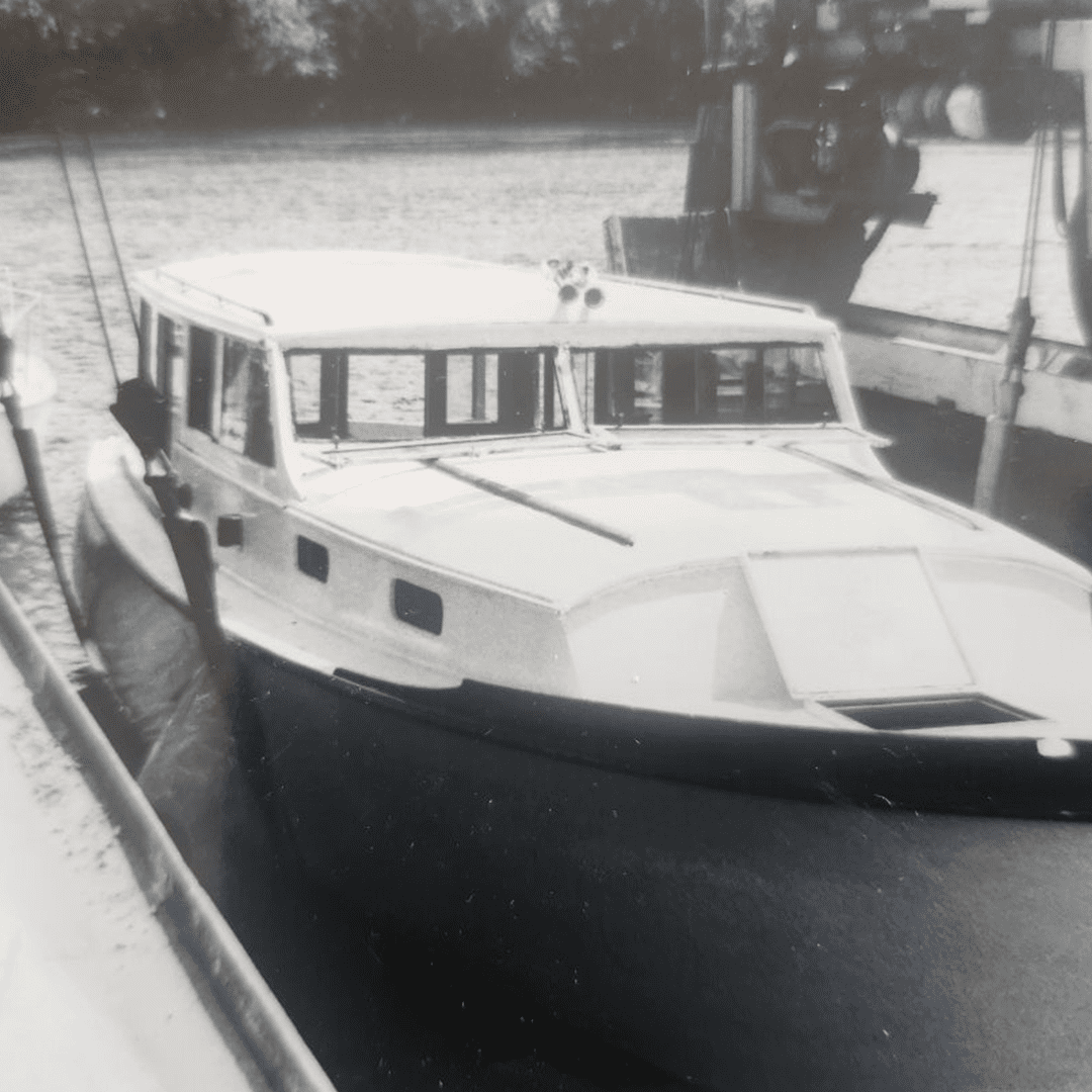 A white cabin cruiser docked at a marina on a cloudy day.