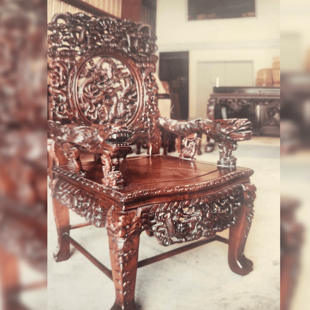 Intricately carved wooden chair with ornate floral and animal designs.