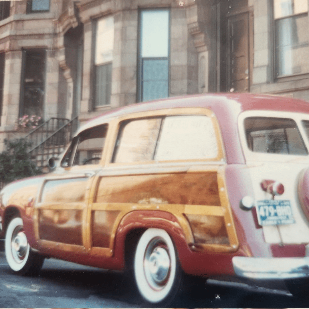 Vintage wood-paneled station wagon parked on a city street.
