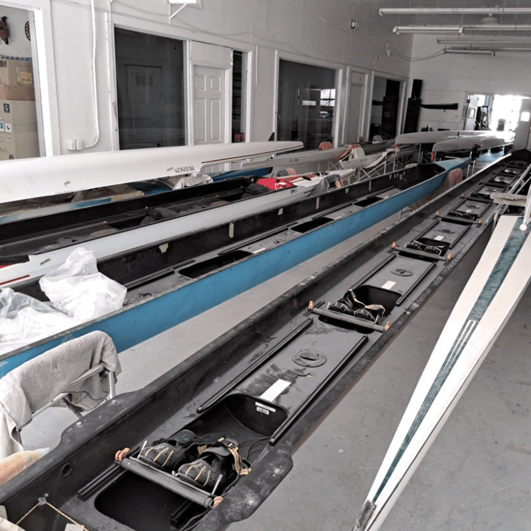Indoor rowing machines lined up in a gym or training facility.