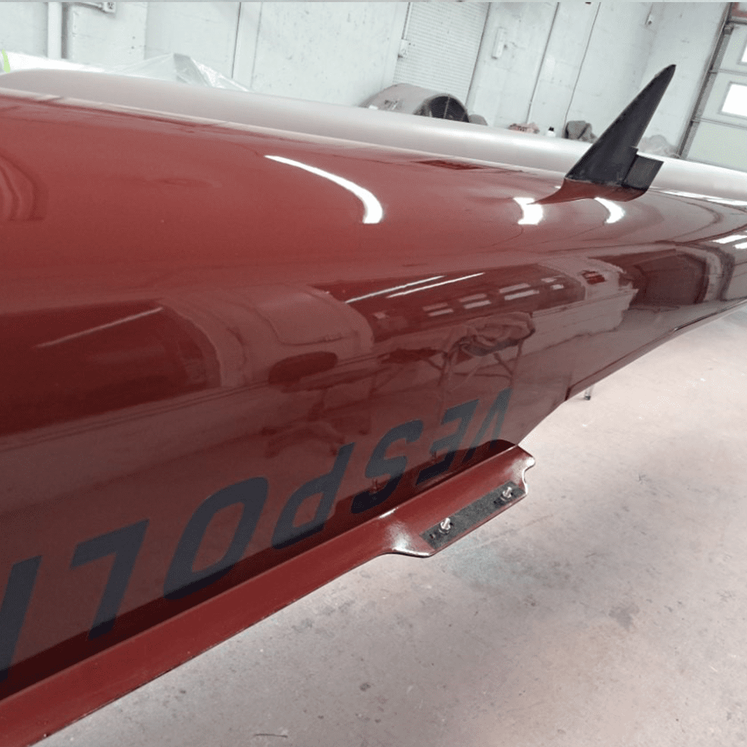 Close-up of a red drone or missile with markings in a hangar.