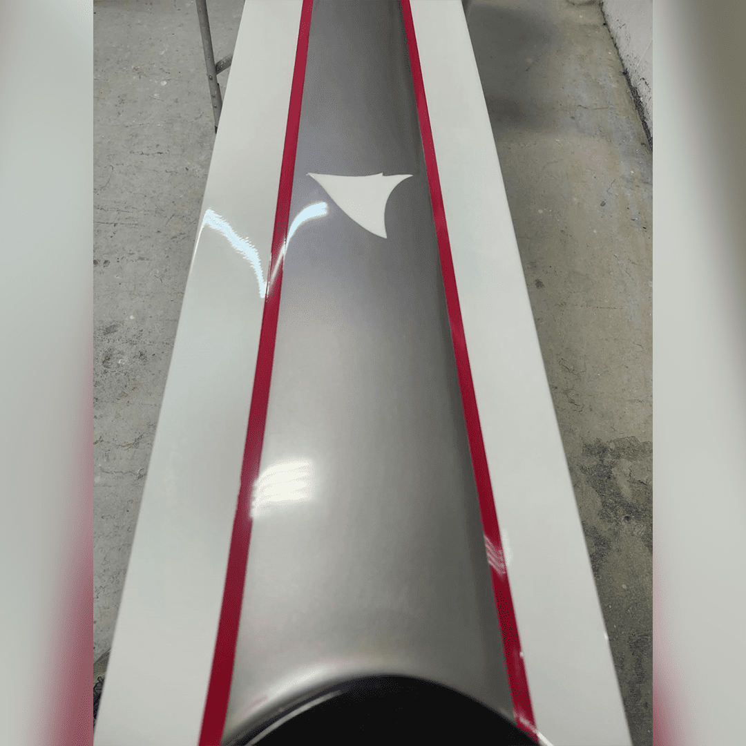 A shiny metallic cylindrical object with red and white packaging.