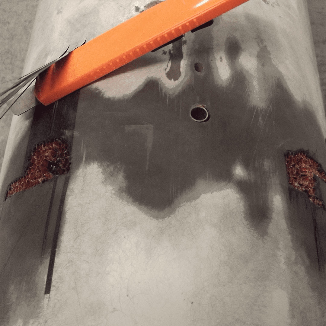 Close-up of a concrete surface with cracks and rust stains near metal rods.