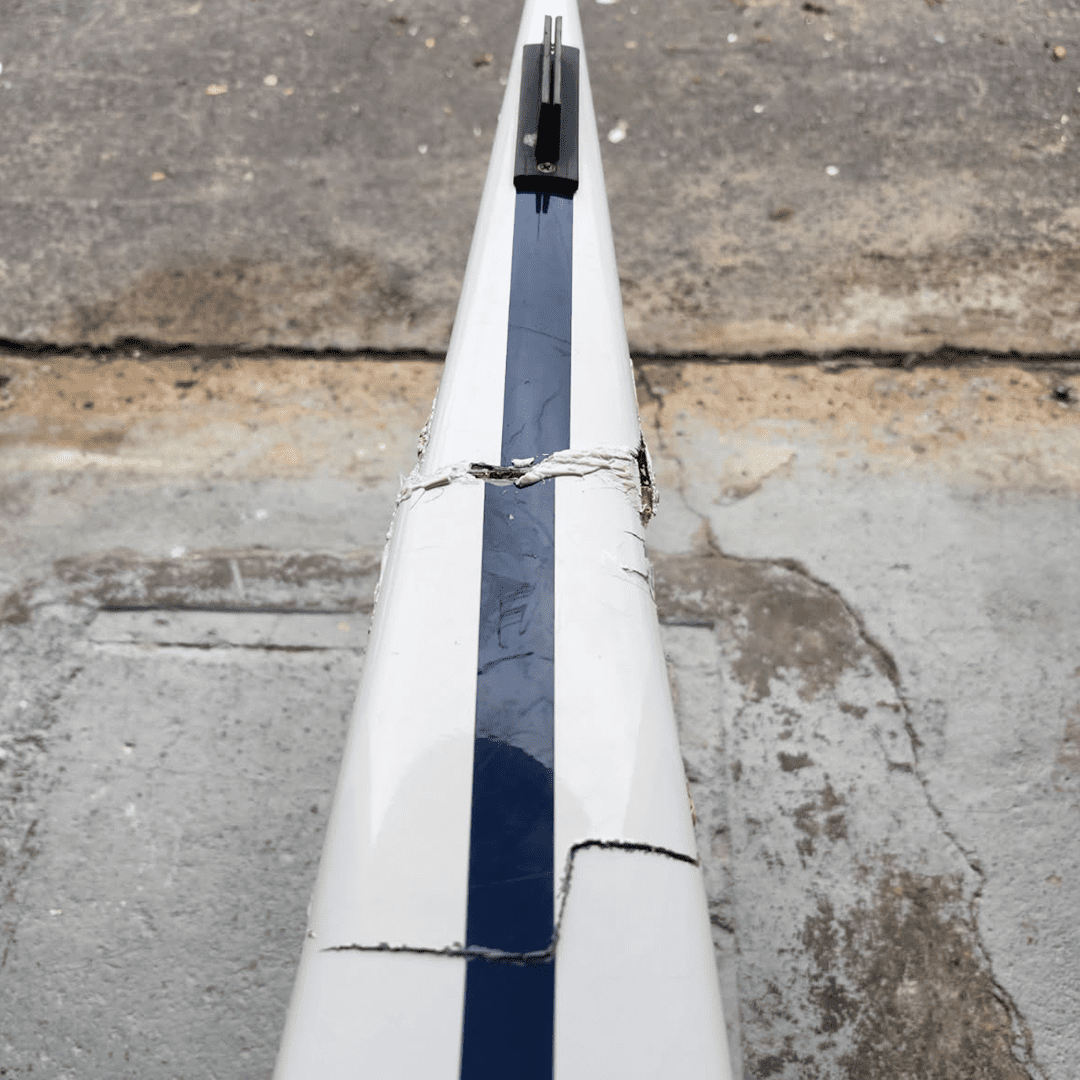 Close-up of a weathered white and blue segmented surface on concrete.