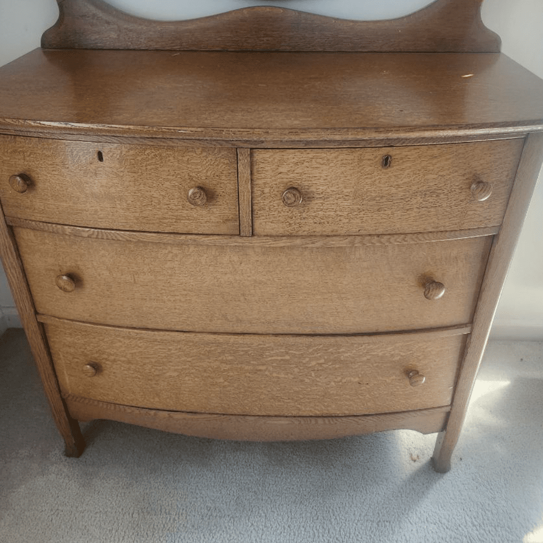 Wooden vintage dresser with four drawers and round knobs.