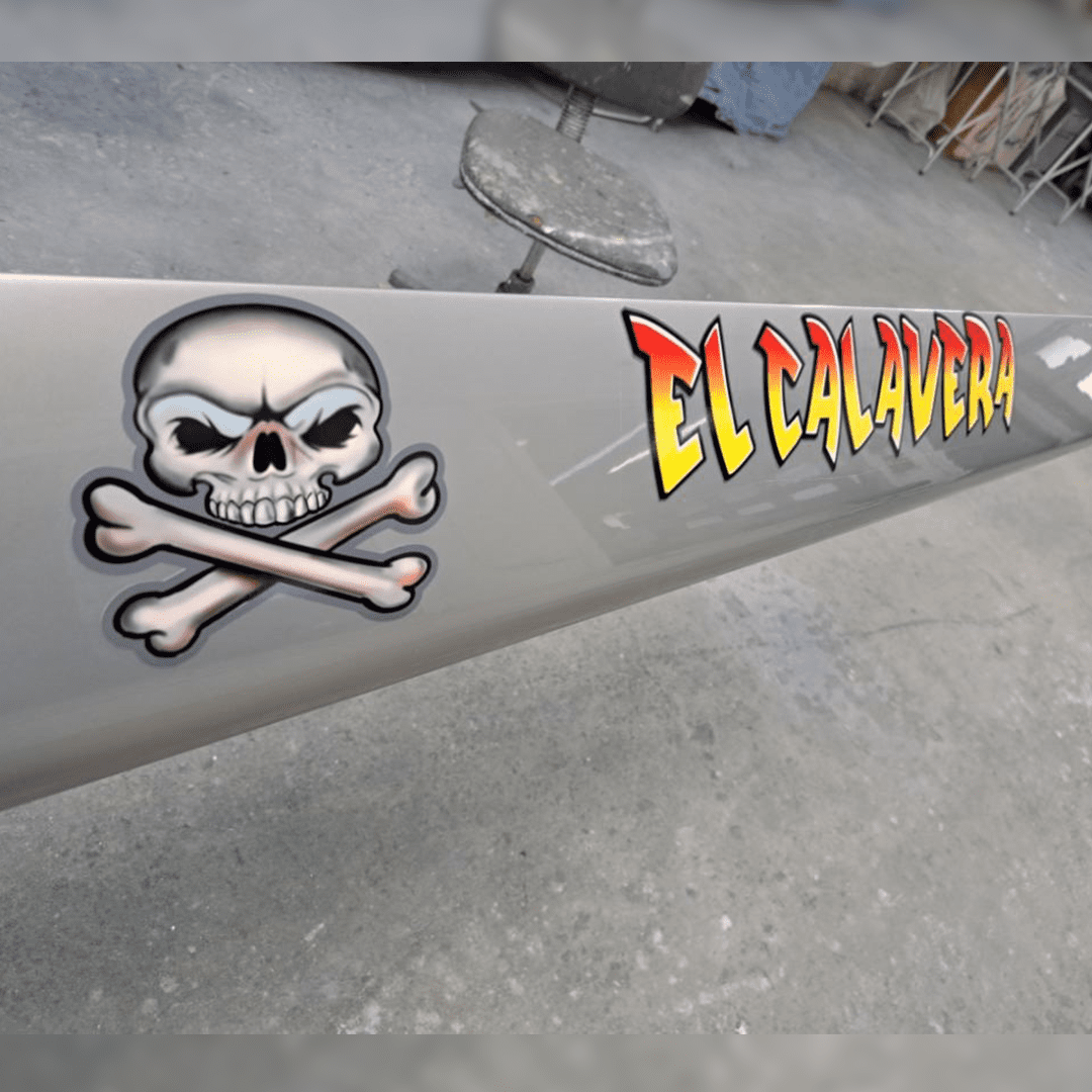 A gray metal pipe with a skull and crossbones sticker and 'El Calaveras' text.