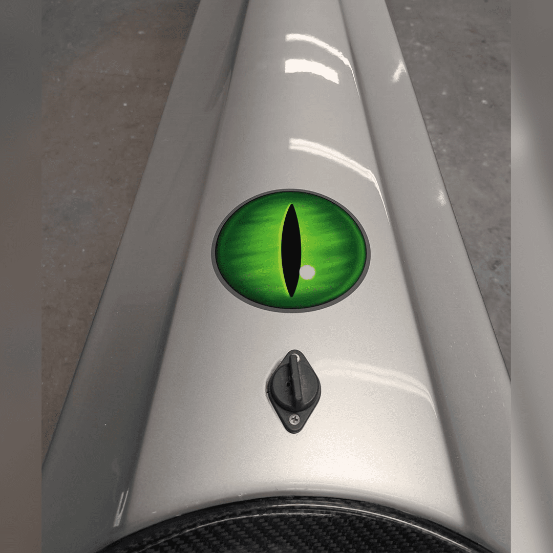 A green reptilian eye decal on a white surface.